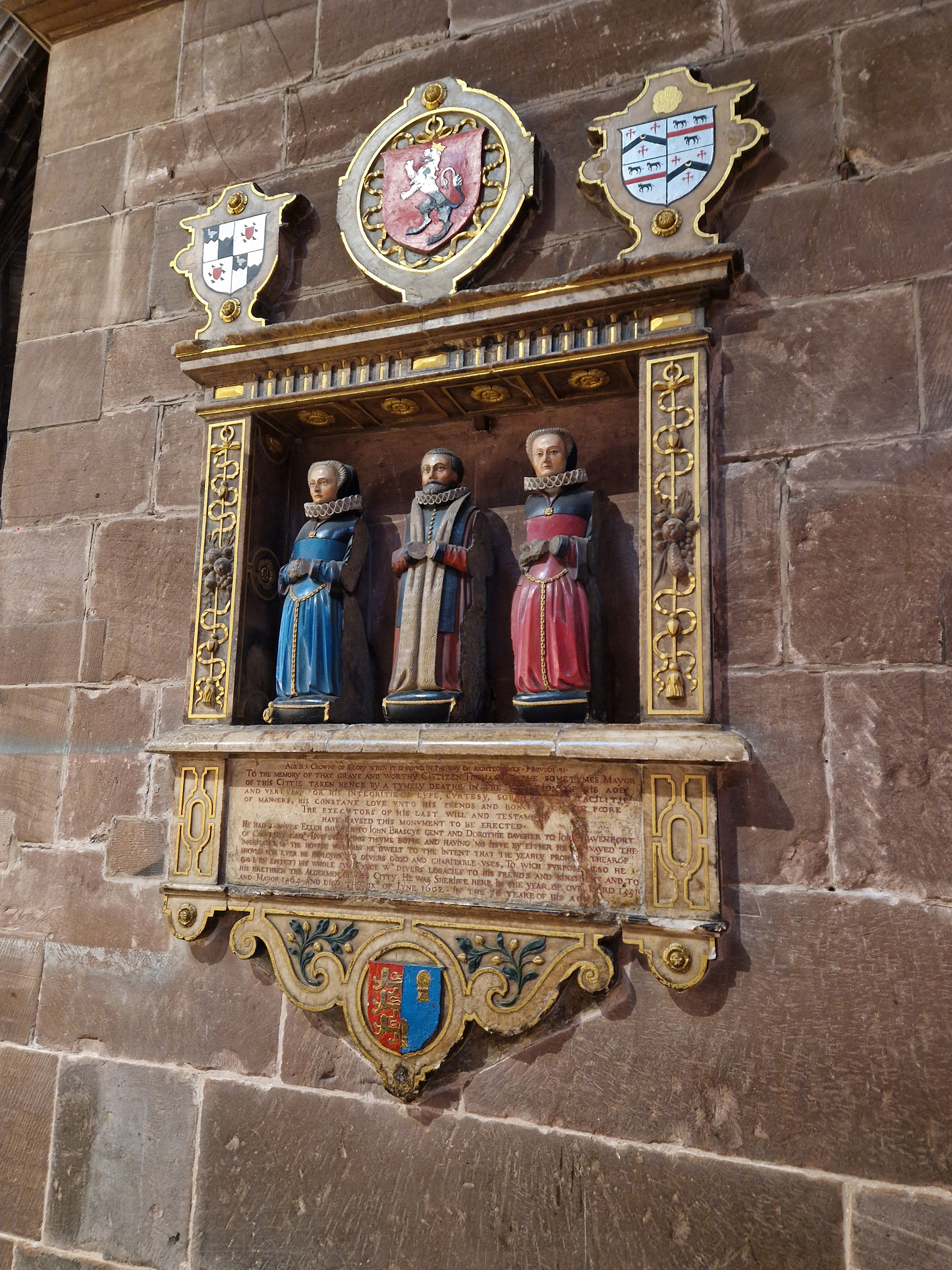 This funeral monument dated 1602 is in Chester cathedral. As the inscription states, it is erected ‘To the memory of that grave and worthy citizen Thomas Greene sometimes Mayor of this Cittie’, and he is depicted kneeling with his hands (now missing) together in prayer, flanked by his two wives. The monument shows them as if at prayer in this space of worship. The inscription records that the monument was erected by the executors of his last will and testament, and this posthumous commemoration by executors was common during the period.<br />
<br />
Thomas Greene is remembered for his ‘integritie of lyfe, curtesy, sobriety and facilitie of manners, his constant love unto his frends and bounty to the poore’. Having no direct heirs, he left his entire inheritance to the benefit ‘of divers good and charitable uses, and to his frends, kinsfolks and to his bethren the aldermen of this citty.’ <br />
<br />
This worthy citizen is set up as an example to others, with his public service to the city – sheriff in the year 1551 and mayor in 1563 – but also his character and charitable bequests to the benefit of others when he died a ‘tymely deathe’ at the age of 76 in 1602.